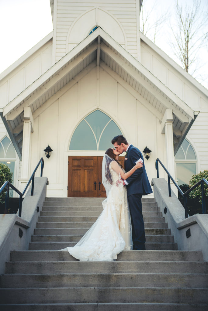 bride and groom kissing on steps of chapel Abernethy Center
