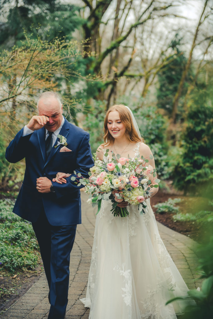 Father tearing up walking daughter down aisle
